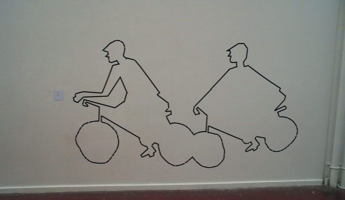 A white wall with the depiction of two cyclists created with black tape. The image is the outline only. 