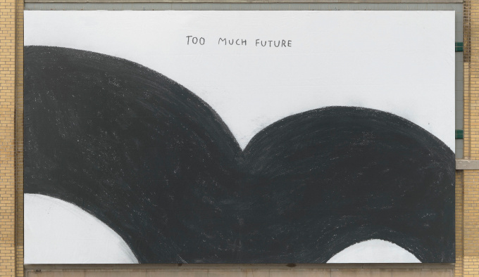 A billboard has the words 'TOO MUCH FUTURE' at the centre top, below this is a thick black curved line which starts from the left hand side, curving down to the centre and then curving back up to the right hand side.