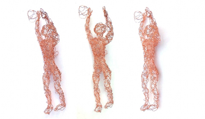 hree sculpted figures in copper wire of basketball players. Their  arms upstretched with a ball by their hands. A sense of movement is captured in both ball and three figures