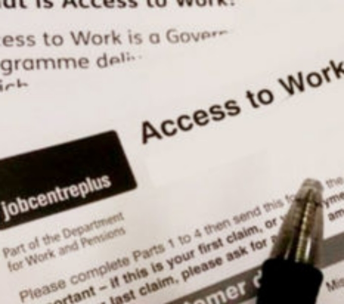 A close up of the black and white text on the Access to Work form with the tip of a black ball point pen held above.