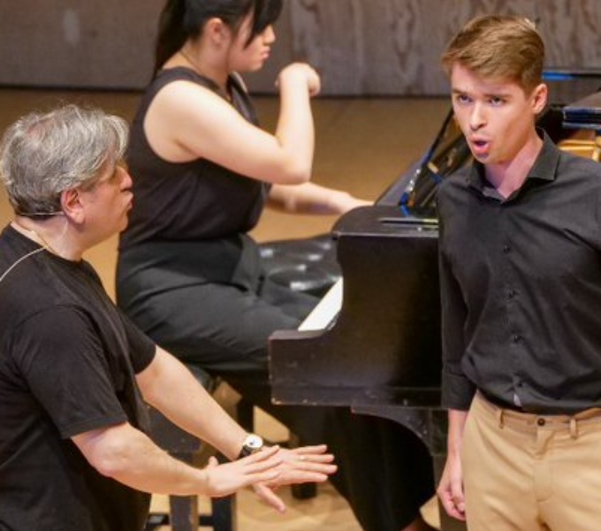 Three people wearing black tee-shirts speak and are moving and talking in dramatic way. 