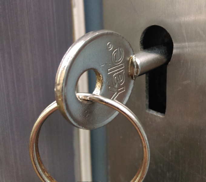 A silver key in the silver keyhole 