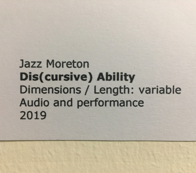 A photograph of typed black text on white paper stating, 'Jazz Moreton, Dis(cursive) Ability, Dimensions / Length: variable, Audio and performance, 2019. 
