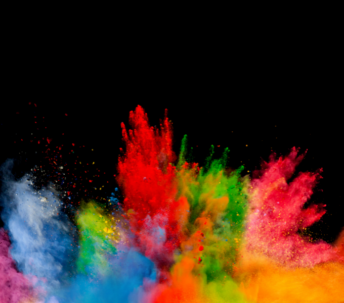 Contrasted against a black background, clouds of red, orange, blue, green and yellow pigment burst upwards and outwards from the bottom of the image.
