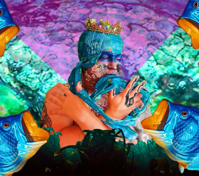 A figure with a painted blue head and a golden crown. Digital imagery gives the effect of a watery background and blue fish appear in each corner of the image.