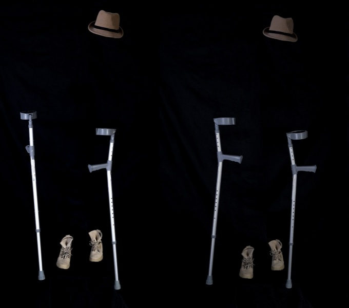 A dark background with three floating hats, 3 pairs of crutches and brown boots. It is as id there is an invisible person wearing them. As the image moves from left to right the crutches, hats and  shoes become more faded.