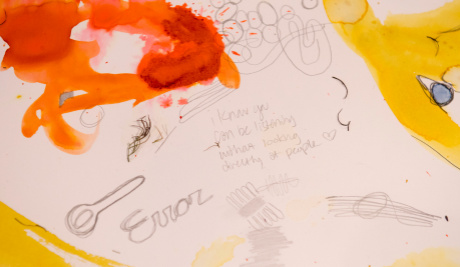 A tablecloth decorated with doodles, writings and yellow and orange splodges