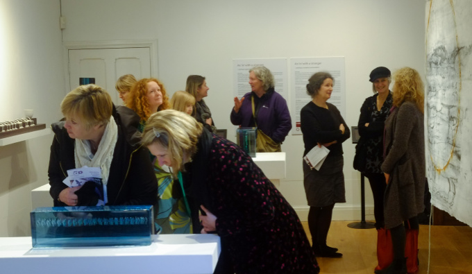 A group of people in a gallery space viewing artworks